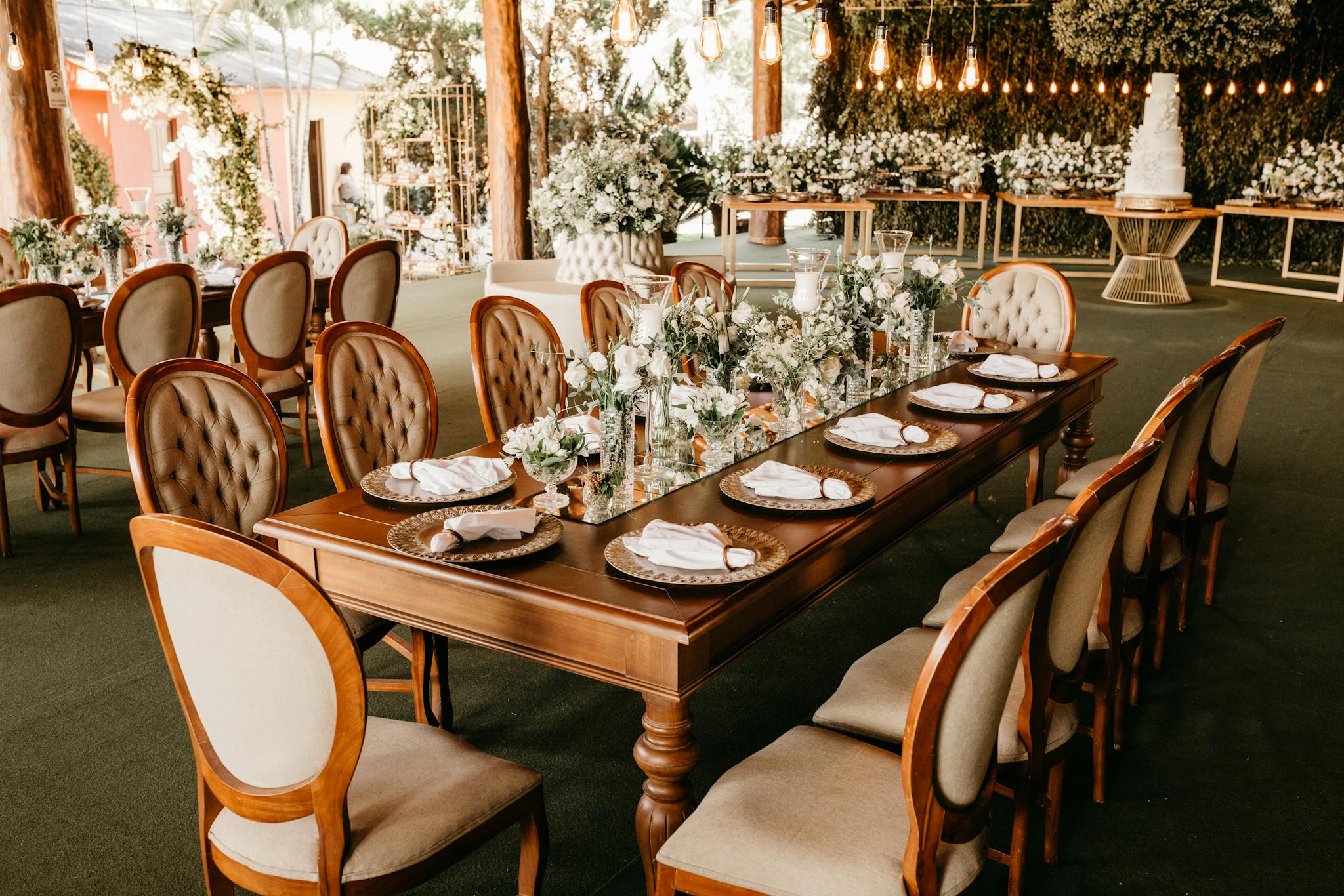 A beautifully decorated wedding venue with elegant table settings, chairs, and floral arrangements.