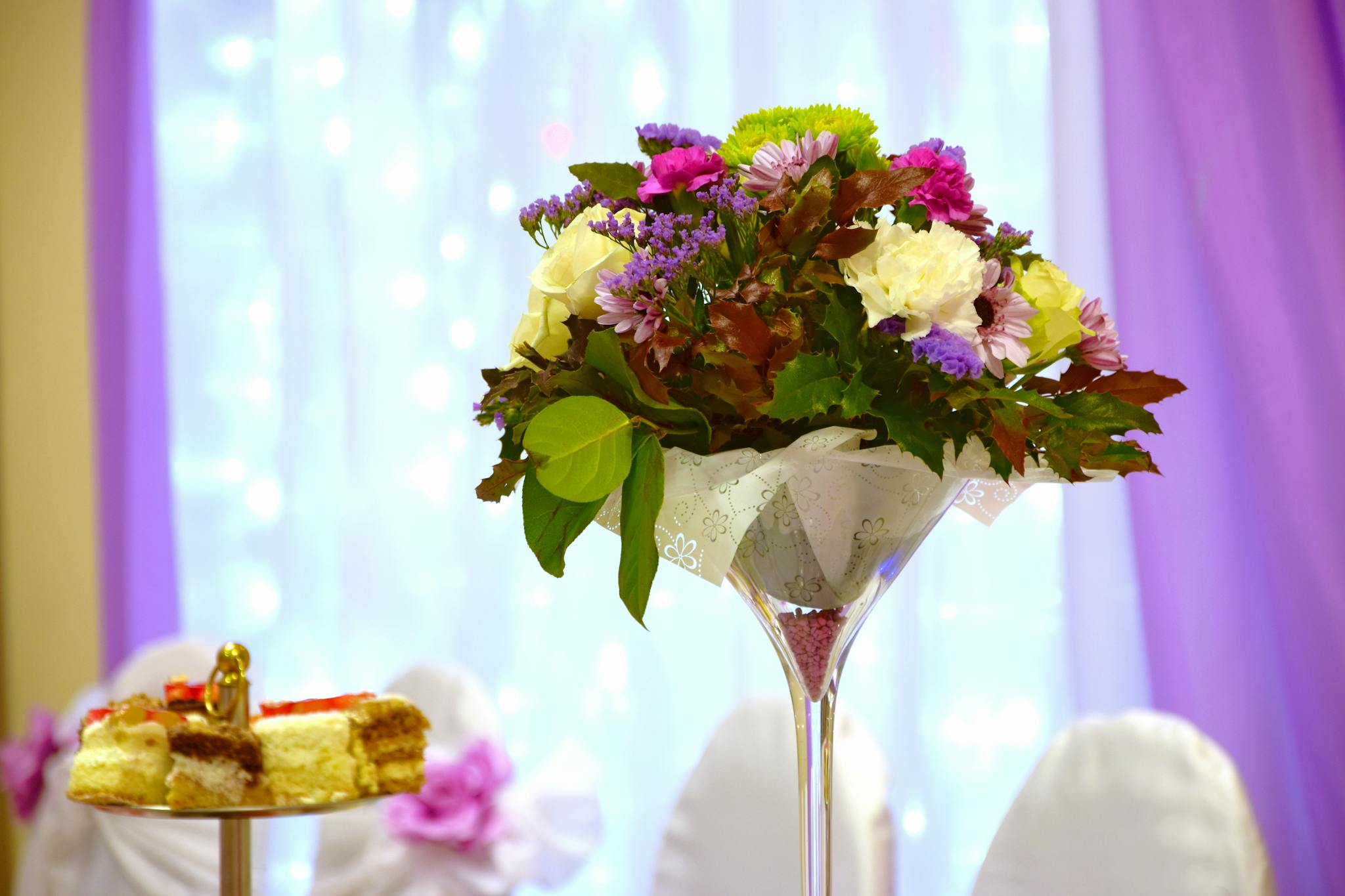 Beautiful floral centerpiece and cakes at an elegant wedding reception setting.